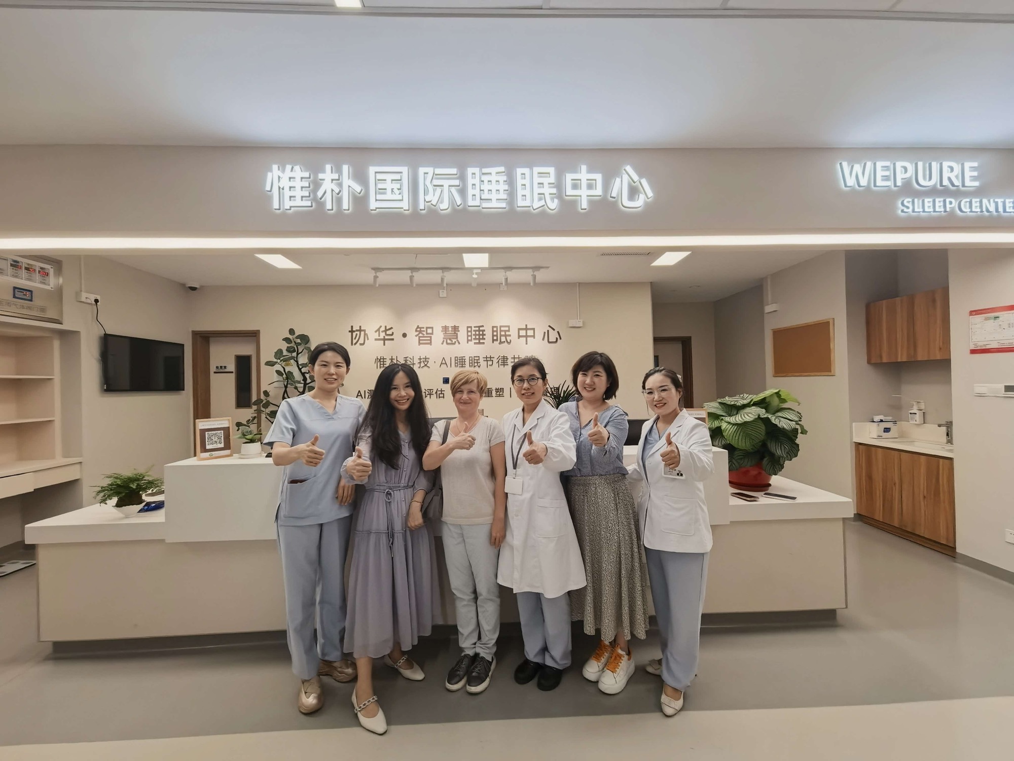 Thumbs-up group photo at Xiehua Smart Sleep Center
